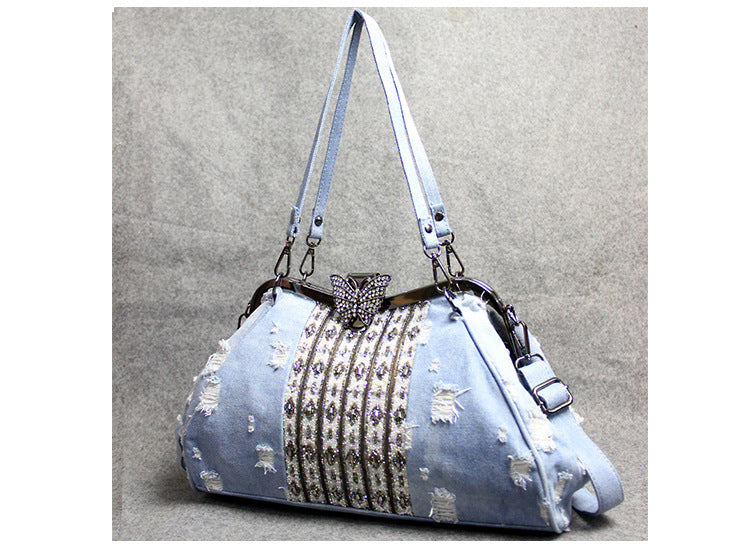 Bolso bandolera de mezclilla azul claro con broche de mariposa y diamantes