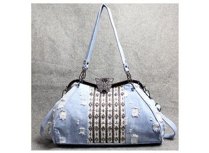 Bolso bandolera de mezclilla azul claro con broche de mariposa y diamantes