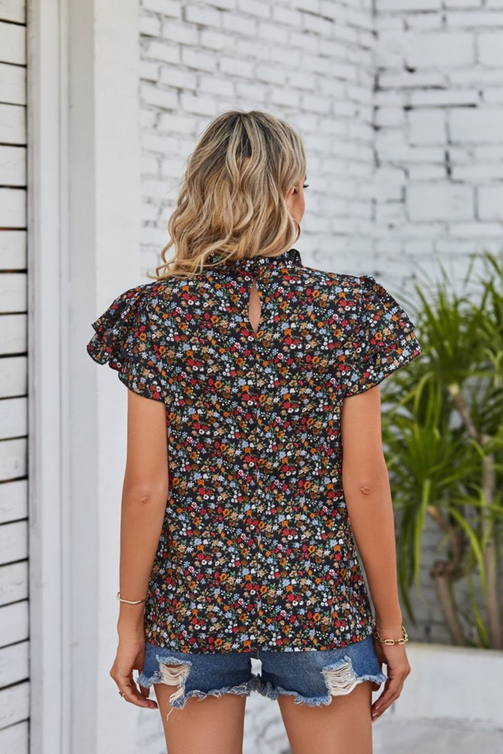 Blusa con mangas acampanadas y cuello con volantes florales