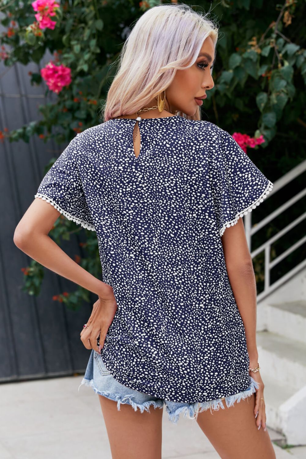 Blusa estampada con mangas de pétalos y detalle de pompones