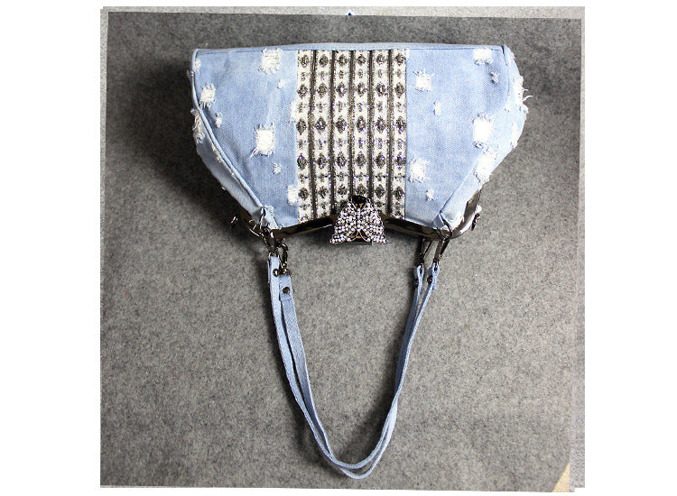 Bolso bandolera de mezclilla azul claro con broche de mariposa y diamantes