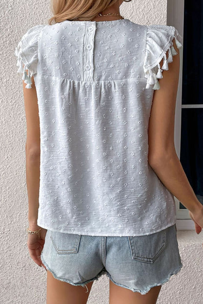 Blusa con cuello redondo y detalle de borlas de lunares suizos