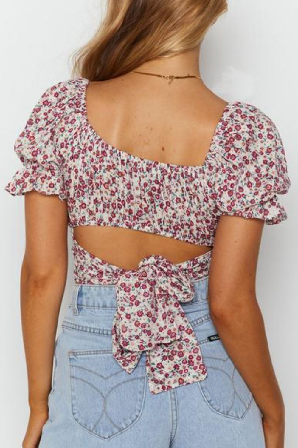 Blusa con lazo en la espalda y hombros descubiertos con ribete de volantes y estampado de flores