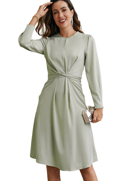 Robe verte torsadée en satin à manches longues et nouée au dos