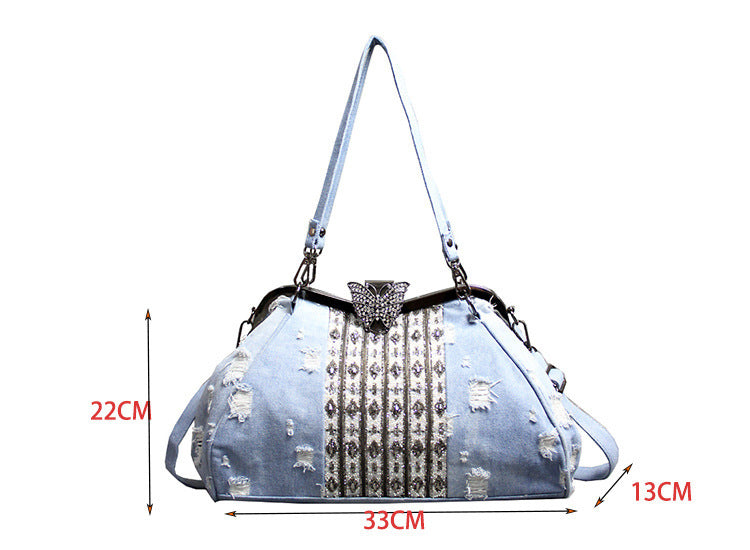 Bolso bandolera de mezclilla azul claro con broche de mariposa y diamantes