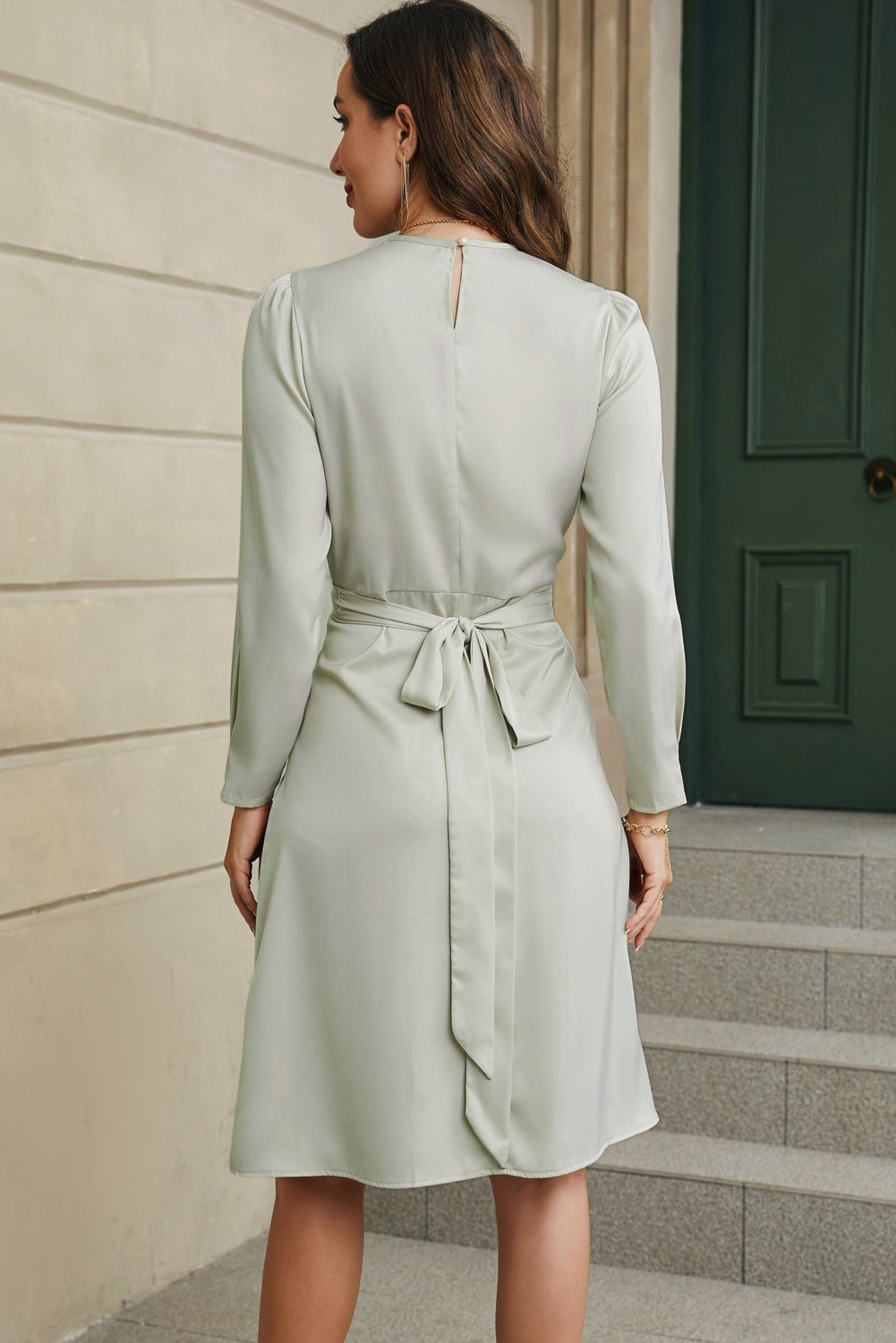 Robe verte torsadée en satin à manches longues et nouée au dos