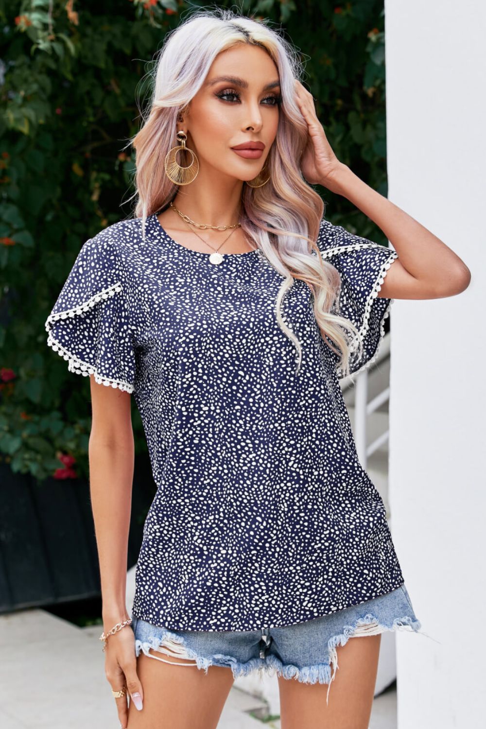 Blusa estampada con mangas de pétalos y detalle de pompones