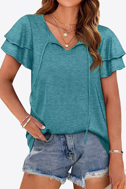 Blusa con mangas acampanadas y capas con cuello anudado