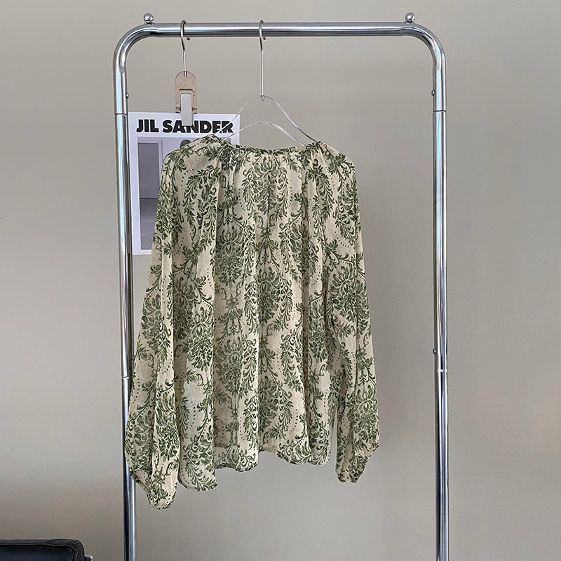 Camisa verde con protección solar ligeramente transparente y manga farol floral