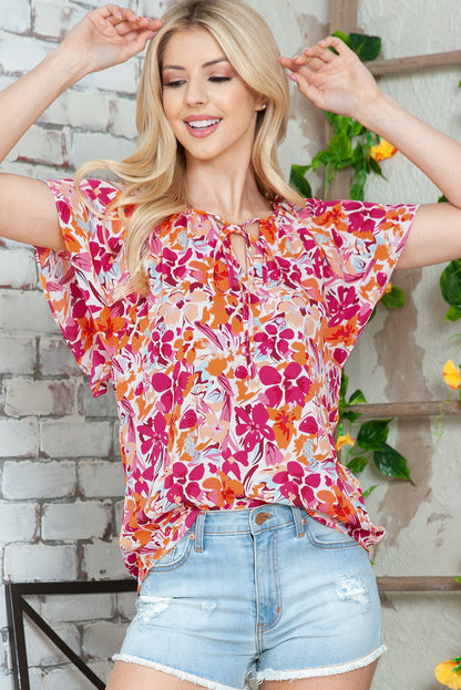 Blusa con mangas abullonadas y cuello con lazo floral