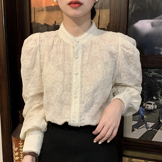 Camisa elegante con adornos de perlas y retales con cuello alto