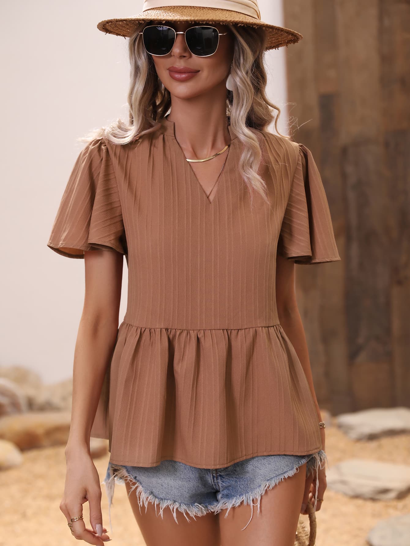 Blusa peplum con muescas y mangas acampanadas de canalé