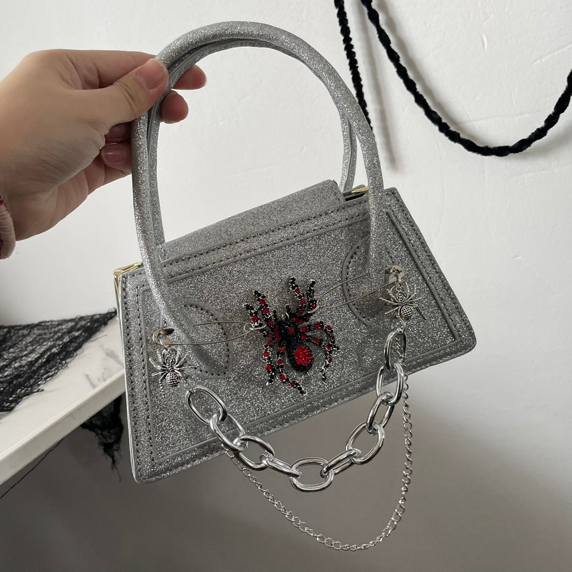 Mini bolso bandolera oscuro con diseño de araña de piel de serpiente